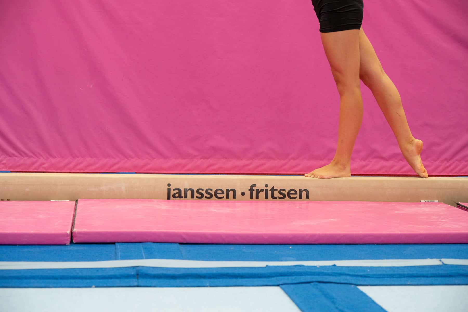 Why girls quit gymnastics: a gymnast walks the length of a balance beam alone in training, her face out of frame